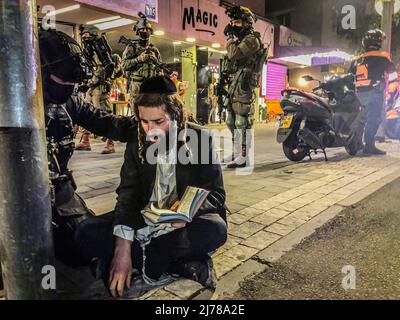 Ein Soldat der israelischen Spezialeinheiten spricht mit einem ultraorthodoxen jüdischen Mann nach einem Schussangriff auf eine Bar in der Dizengoff Street in Tel Aviv. Zwei Menschen wurden getötet und zehn wurden am Donnerstagabend verletzt, nachdem ein Schütze im Zentrum von Tel Aviv das Feuer eröffnet hatte, das jüngste einer Reihe tödlicher Terrorangriffe auf Israel. Der Angreifer wurde am frühen Freitagmorgen in Jaffa getötet. Die beiden getöteten Männer waren 27 und 28 Jahre alt. Stockfoto