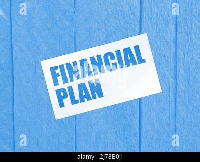 Finanzplan Wörter auf Karte auf Holztisch. Konzept der Geschäftsverschuldung. Stockfoto