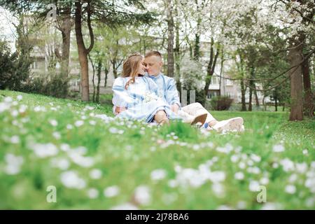 Liebevolles Paar, das im Frühling im Park sitzt Stockfoto