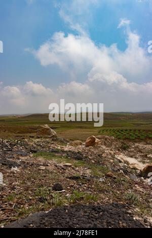 Am Berghang landwirtschaftlich bewirtschaftete Felder mit hellblauem Himmel am Morgen aus flachem Winkel Stockfoto