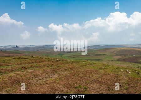 Am Berghang landwirtschaftlich bewirtschaftete Felder mit hellblauem Himmel am Morgen aus flachem Winkel Stockfoto