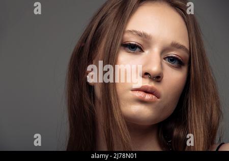 Portrait schönes Modell posiert im Studio auf grauem Hintergrund. Kaukasische Porträtfrau. Stockfoto