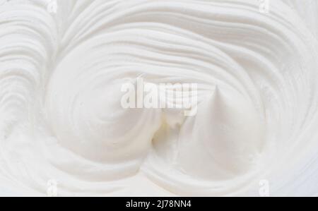 Cremige Pics und Wirbel in Joghurt oder Creme Oberfläche. Draufsicht. Stockfoto