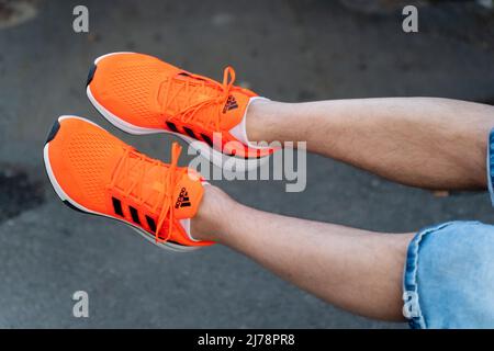 Tyumen, Russland-03. Mai 2022: Adidas Herren Sneaker orange ist ein deutsches Unternehmen, das Sportschuhe, Bekleidung und Accessoires entwirft und herstellt Stockfoto