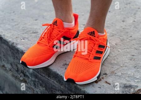 Tjumen, Russland-03. Mai 2022: Adidas Logo und Schuhe. Adidas ist ein deutscher multinationaler Konzern, der Schuhe entwirft und herstellt. Stockfoto