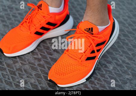 Tjumen, Russland-03. Mai 2022: Adidas Logo und Schuhe. Adidas ist ein deutscher multinationaler Konzern, der Schuhe entwirft und herstellt. Stockfoto