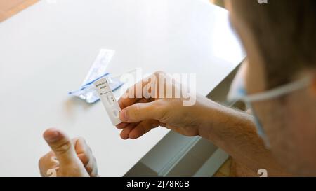 Male Hold Coronavirus atk Ergebnis mit 1 Streifen, nicht infiziert, nehmen Gesichtsmaske ab Stockfoto