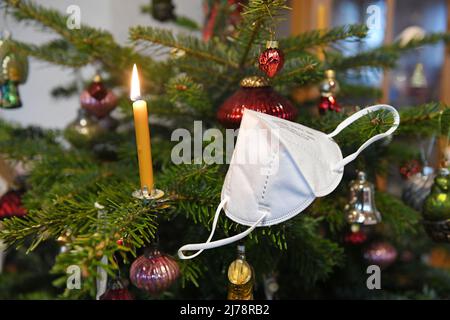 FFP2-Maske hängt auf einem Weihnachtsbaum, Österreich, Europa - FFP2 Maske hängt an einem Weihnachtsbaum, Österreich, Europa Stockfoto