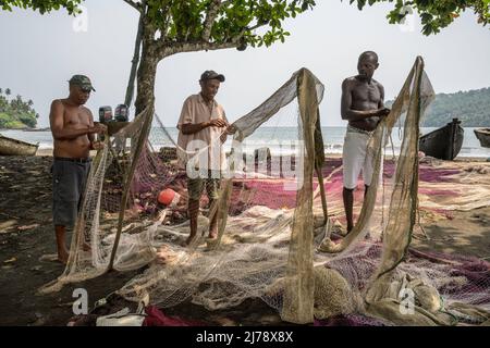 Fischer reparieren die Fischernetze, bevor sie zum Fischen ausgehen. Stockfoto