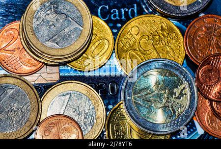 Makroaufnahme verschiedener europäischer Münzen, die auf einer Kreditkarte liegen. Stockfoto
