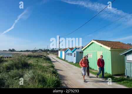 Touristen, die auf einem Küstenwanderweg am Austernfarm Fort Royer, Charente Maritime, Frankreich, spazieren Stockfoto