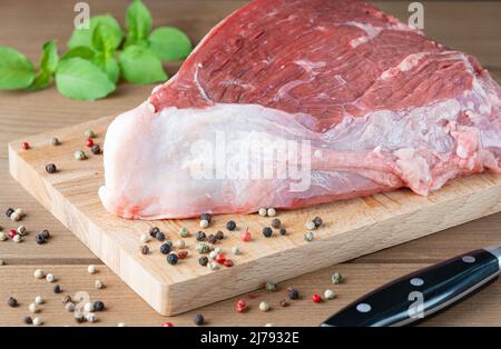 Frisches rohes Rindfleisch mit Gewürzen auf einem Holztisch Stockfoto