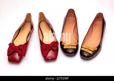 Glänzende weibliche Lackleder Ballerina flache Schuhe mit dekorativen Schleifen isoliert auf weißem Hintergrund Stockfoto