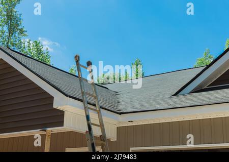 Neu installiertes Dach mit Asphaltschindeln mit Bitumenfliesen auf dem Dach des neuen Hauses Stockfoto
