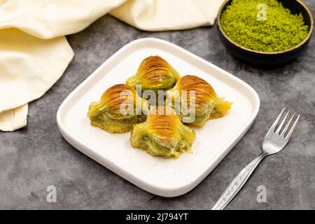 Muschel Baklava. Pistazien-Baklava auf dunklem Hintergrund. Köstlichkeiten der mediterranen Küche. Nahaufnahme. Lokaler Name midye baklava Stockfoto