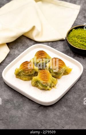 Muschel Baklava. Pistazien-Baklava auf dunklem Hintergrund. Köstlichkeiten der mediterranen Küche. Nahaufnahme. Lokaler Name midye baklava Stockfoto