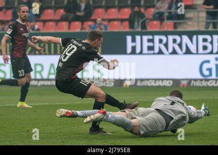 07. Mai 2022, Bayern, Ingolstadt: Fußball: 2. Bundesliga, FC Ingolstadt 04 - Hansa Rostock, Matchday 33, Audi Sportpark. Ingolstadts Marcel Gaus (l) schlägt Rostocker Torwart Markus Kolke nicht. Foto: Stefan Puchner/dpa - WICHTIGER HINWEIS: Gemäß den Anforderungen der DFL Deutsche Fußball Liga und des DFB Deutscher Fußball-Bund ist es untersagt, im Stadion und/oder des Spiels aufgenommene Fotos in Form von Sequenzbildern und/oder videoähnlichen Fotoserien zu verwenden oder zu verwenden. Stockfoto