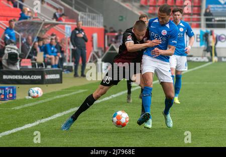 07. Mai 2022, Bayern, Ingolstadt: Fußball: 2. Bundesliga, FC Ingolstadt 04 - Hansa Rostock, Matchday 33, Audi Sportpark. Ingolstadts Filip Bibija (l.) und Rostocks Tobias Schwede kämpfen um den Ball. Foto: Stefan Puchner/dpa - WICHTIGER HINWEIS: Gemäß den Anforderungen der DFL Deutsche Fußball Liga und des DFB Deutscher Fußball-Bund ist es untersagt, im Stadion und/oder des Spiels aufgenommene Fotos in Form von Sequenzbildern und/oder videoähnlichen Fotoserien zu verwenden oder zu verwenden. Stockfoto