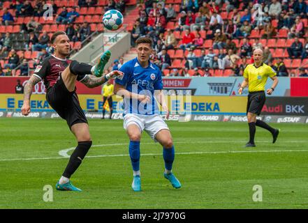 07. Mai 2022, Bayern, Ingolstadt: Fußball: 2. Bundesliga, FC Ingolstadt 04 - Hansa Rostock, Matchday 33, Audi Sportpark. Der Ingolstädter Patrick Schmidt (l) kommt vor dem Rostocker Jonathan Meier an den Ball. Foto: Stefan Puchner/dpa - WICHTIGER HINWEIS: Gemäß den Anforderungen der DFL Deutsche Fußball Liga und des DFB Deutscher Fußball-Bund ist es untersagt, im Stadion und/oder des Spiels aufgenommene Fotos in Form von Sequenzbildern und/oder videoähnlichen Fotoserien zu verwenden oder zu verwenden. Stockfoto