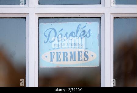 Nahaufnahme auf einem geschlossenen Schild mit der Aufschrift „Désolés, nous sommes fermés“ auf Französisch, was auf Englisch „Sorry we are closed“ bedeutet. Stockfoto