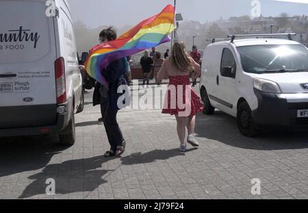 Falmouth Cornwall, Großbritannien 07.. Mai 2022. Eine heldenhaft stellvertretende Bürgermeisterin der Stadt Falmouth, die voll von der Bürokette ist und ihre „Rainbow Pride“-Flagge hält, sieht, wie sie in einem Steak-Restaurant auf dem Event Square der Stadt Falmouth auf ein Feuer zuläuft. Die Big Gay Pride Unterhaltungsstätte musste für die Sicherheit der anwesenden Massen evakuiert werden. Ratsmitglied Kirsty Edwards ist ein eifriger Befürworter der Minderheitenrechte. Falmouth Cornwall Robert Taylor Alamy Live News Stockfoto