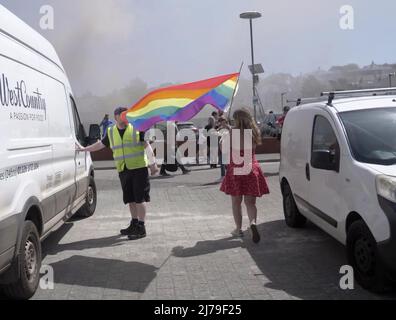 Falmouth Cornwall, Großbritannien 07.. Mai 2022. Eine heldenhaft stellvertretende Bürgermeisterin der Stadt Falmouth, die voll von der Bürokette ist und ihre „Rainbow Pride“-Flagge hält, sieht, wie sie in einem Steak-Restaurant auf dem Event Square der Stadt Falmouth auf ein Feuer zuläuft. Die Big Gay Pride Unterhaltungsstätte musste für die Sicherheit der anwesenden Massen evakuiert werden. Ratsmitglied Kirsty Edwards ist ein eifriger Befürworter der Minderheitenrechte. Falmouth Cornwall Robert Taylor Alamy Live News Stockfoto