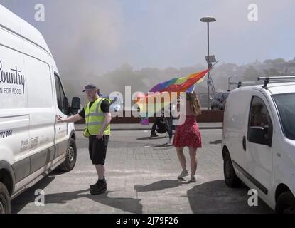 Falmouth Cornwall, Großbritannien 07.. Mai 2022. Eine heldenhaft stellvertretende Bürgermeisterin der Stadt Falmouth, die voll von der Bürokette ist und ihre „Rainbow Pride“-Flagge hält, sieht, wie sie in einem Steak-Restaurant auf dem Event Square der Stadt Falmouth auf ein Feuer zuläuft. Die Big Gay Pride Unterhaltungsstätte musste für die Sicherheit der anwesenden Massen evakuiert werden. Ratsmitglied Kirsty Edwards ist ein eifriger Befürworter der Minderheitenrechte. Falmouth Cornwall Robert Taylor Alamy Live News Stockfoto