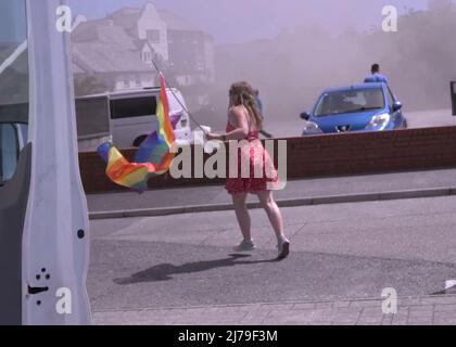 Falmouth Cornwall, Großbritannien 07.. Mai 2022. Eine heldenhaft stellvertretende Bürgermeisterin der Stadt Falmouth, die voll von der Bürokette ist und ihre „Rainbow Pride“-Flagge hält, sieht, wie sie in einem Steak-Restaurant auf dem Event Square der Stadt Falmouth auf ein Feuer zuläuft. Die Big Gay Pride Unterhaltungsstätte musste für die Sicherheit der anwesenden Massen evakuiert werden. Ratsmitglied Kirsty Edwards ist ein eifriger Befürworter der Minderheitenrechte. Falmouth Cornwall Robert Taylor Alamy Live News Stockfoto
