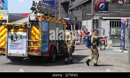 Falmouth Cornwall, Großbritannien 07.. Mai 2022. Eine heldenhaft stellvertretende Bürgermeisterin der Stadt Falmouth, die voll von der Bürokette ist und ihre „Rainbow Pride“-Flagge hält, sieht, wie sie in einem Steak-Restaurant auf dem Event Square der Stadt Falmouth auf ein Feuer zuläuft. Die Big Gay Pride Unterhaltungsstätte musste für die Sicherheit der anwesenden Massen evakuiert werden. Ratsmitglied Kirsty Edwards ist ein eifriger Befürworter der Minderheitenrechte. Falmouth Cornwall Robert Taylor Alamy Live News Stockfoto