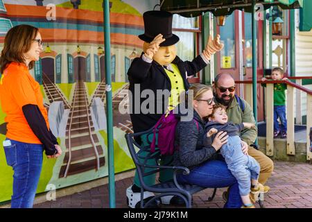 Ronks, PA, USA - 30. April 2022: Sir Topham Hatt posiert mit einer Familie für ein Foto während der Thomas the Tank Engine Days an der Strasburg Rail Road in Stockfoto