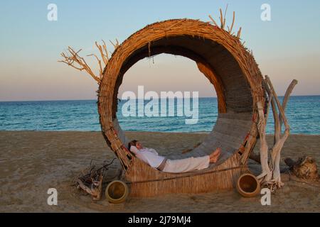 Weibliche Touristen entspannen sich in einer schicken Sonnenliege im Hotel Regency Sealine Camp in Khor Al Adaid, Katar, 04. Dezember 2021. © Peter Schatz / Alamy Live News Stockfoto