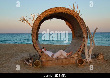 Weibliche Touristen entspannen sich in einer schicken Sonnenliege im Hotel Regency Sealine Camp in Khor Al Adaid, Katar, 04. Dezember 2021. © Peter Schatz / Alamy Live News Stockfoto