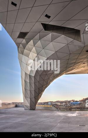 Ein organischer facettierter pilar, einer der bedeutendsten Merkmale des Musée des Confluences in Lyon, Frankreich bei Nacht. Das Gebäude ist dekonstruktivistisch Stockfoto