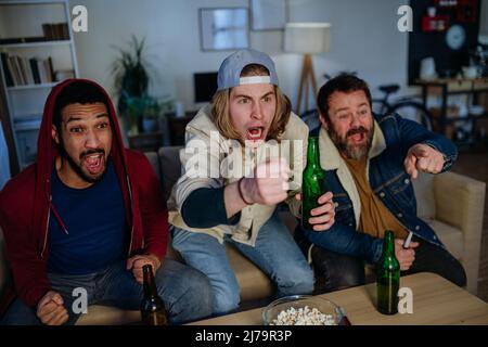 Happy Football Fans Freunde sehen Fußball zu Hause und feiern Stockfoto
