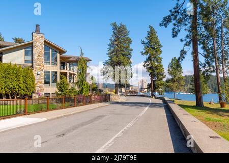 Luxuriöse Häuser am Wasser blicken auf den See mit dem Stadtstrand, Park und Downtown Resort und Marina in Coeur d'Alene, Idaho, USA. Stockfoto