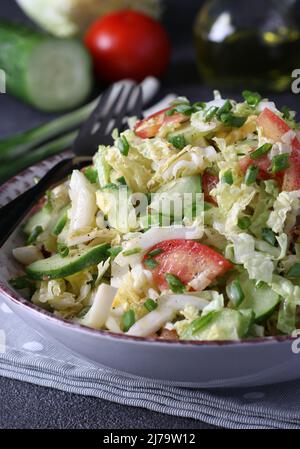 Salat mit Chinakohl, Tomaten, Schnittlauch, Eiern und Gurken, mit Olivenöl, Vertikal-Format Stockfoto