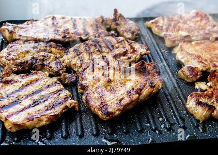 Saftige Schweinehals-Steaks auf Teflon-Barbecue-Grill Stockfoto