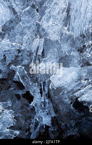 Makro-Nahaufnahme von abstrakten Eisformationen im Winter, von oben betrachtet. Abstrakter, strukturierter Hintergrund mit Vollformat und Kopierbereich. Draufsicht. Stockfoto