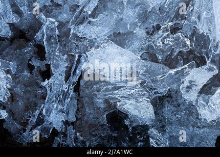 Makro-Nahaufnahme von abstrakten Eisformationen im Winter, von oben betrachtet. Abstrakter, strukturierter Hintergrund mit Vollformat und Kopierbereich. Draufsicht. Stockfoto