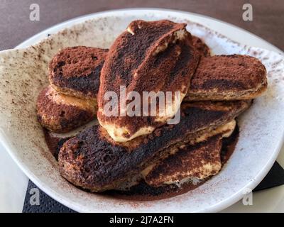 Tiramisu, das traditionelle italienische Dessert auf dem Teller ist Stockfoto