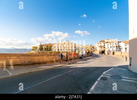 Touristen gehen über die Puente Viejo Alte Brücke in Richtung Altstadt in der andalusischen Stadt Ronda, Spanien. Stockfoto