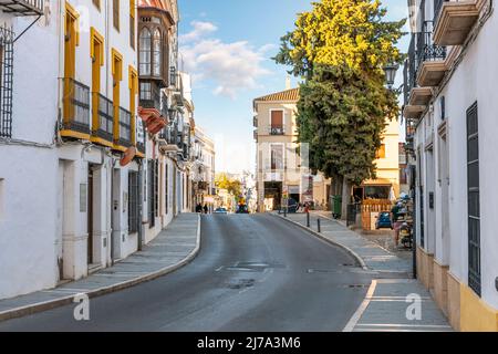 Eine der traditionellen Straßen mit Häusern und kleinen Geschäften in der historischen Altstadt des andalusischen Dorfes Ronda, Spanien Stockfoto