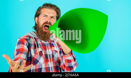 Mann schreit im Lautsprecher. Bärtiger Kerl, der im Bullhorn brüllt. Hipster mit Megaphon. Rabatt, Verkauf. Stockfoto