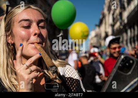 Madrid, Spanien. 07.. Mai 2022. Eine Frau wird gesehen, wie sie während des globalen Marsches von Marihuana einen großen Joint raucht. Tausende von Menschen marschieren durch das Stadtzentrum, um ein Gesetz zur Legalisierung von Cannabis zu fordern. Der Global Marijuana March findet jedes Jahr am ersten Samstag im Mai in vielen Städten auf der ganzen Welt statt. Quelle: Marcos del Mazo/Alamy Live News Stockfoto