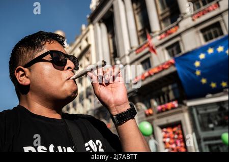 Madrid, Spanien. 07.. Mai 2022. Während des globalen Marsches von Marihuana wird ein Mann gesehen, der ein großes Joint raucht. Tausende von Menschen marschieren durch das Stadtzentrum, um ein Gesetz zur Legalisierung von Cannabis zu fordern. Der Global Marijuana March findet jedes Jahr am ersten Samstag im Mai in vielen Städten auf der ganzen Welt statt. Quelle: Marcos del Mazo/Alamy Live News Stockfoto