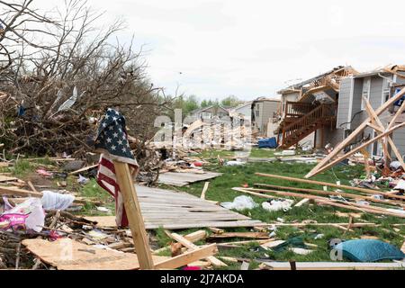 Andover, Vereinigte Staaten von Amerika. 29. April 2022. Eine zerfetzte amerikanische Flagge hängt an einer Stange vor beschädigten Häusern nach einem EF-3 Tornado, 29. April 2022, in Andover, Kansas. Der Tornado beschädigte Hunderte von Gebäuden im Vorort Wichita. Kredit: A1c Felicia Przydzial/USA Air Force Photo/Alamy Live News Stockfoto