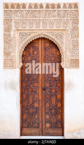 Beispiel mittelalterlicher geometrischer Ornamente an alten Holztüren in Granada, Andalusien, Spanien Stockfoto