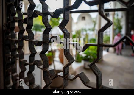 Beispiel für mittelalterliche maurische symmetrische und geometrische Ornamente an Eisentüren in Granada, Andalusien, Spanien Stockfoto