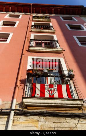 Bilbao, Spanien - 29. Januar 2022:. Flagge des Athletic Club von Bilbao auf einer Balkonfassade des Gebäudes. Stockfoto