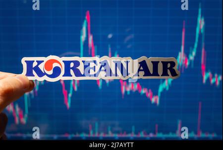 10. November 2021, Seoul, Südkorea. Das Emblem der koreanischen Fluggesellschaft Air vor dem Hintergrund einer Aktienkurskarte. Stockfoto